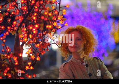 Porträt einer Frau in künstlerischem Neonlicht auf einer nächtlichen Stadtstraße Stockfoto