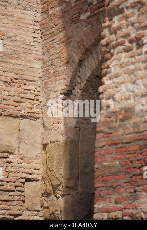 Strukturiertes altes rotes Ziegelwerk und Steinfundament einer historischen Festung oder Kirchenmauer Stockfoto