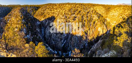 Das Luftpanorama zeigt die schneebedeckte Landschaft des Walnut Canyon unter hellem Sonnenlicht in Arizona Stockfoto