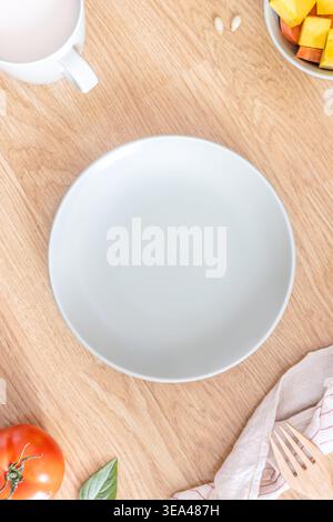 Eine Nahaufnahme einer leeren hellgrünen Platte auf einem Holztisch zum Frühstück. Das Konzept der ausgewogenen Ernährung. Draufsicht. Flache Lagen. Stockfoto