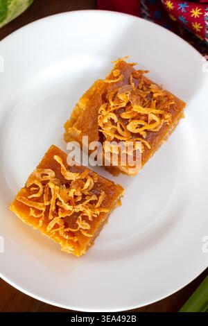 Eine Nahaufnahme von thailändischem Mungbohnen-Pudding oder thailändischem Pudding-Kuchen auf dem Holztisch, ein traditionelles thailändisches Dessert. Draufsicht. Flache Lagen. Stockfoto