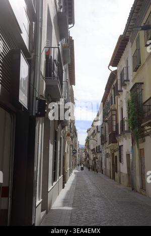 Enge Kopfsteinpflasterstraße gesäumt von weiß getünchten Gebäuden und Balkonen in Granadas historischem Viertel Andalusien Stockfoto