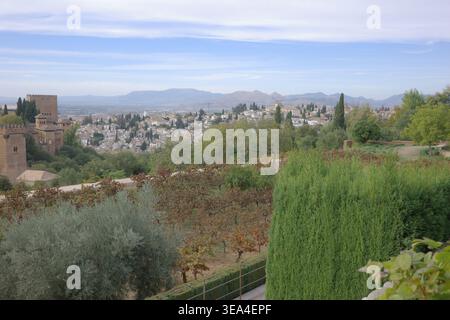 Panoramablick auf Albaicín und Sierra Nevada von den Gärten des Generalife, mit den Nasriden Türmen der Alhambra auf der linken Seite, Granada, Andalusien, Spanien. Stockfoto