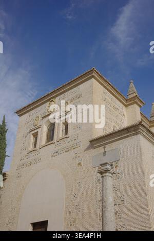 Kunstvolle Mudéjar-Backsteinfassade der Kirche im Alhambra-Komplex mit dekorativen Steineinlagen, Wappenmedaillons und bogenförmigem Eingang Stockfoto