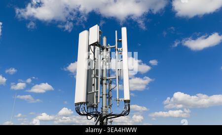 Luftaufnahme von Telekommunikationsantennen und Mobilgeräten auf einem Mast vor blauem Himmel mit weißen Wolken in Amsterdam, Noord-Holland, Niederlande Stockfoto