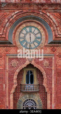 Blick aus der Vogelperspektive auf die komplizierte maurische Fassade des Schlosses Sammezzano mit einer großen Uhr und verzierten Ziegeleien in Reggello, Toskana, Italien. Stockfoto