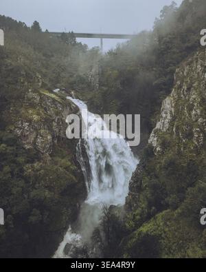 Aus der Vogelperspektive auf den wunderschönen Wasserfall Fervenza do Toxa, der durch einen üppigen Wald und felsige Klippen fällt, Silleda, Pontevedra, Spanien. Stockfoto