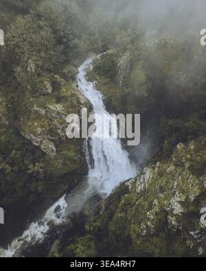 Aus der Vogelperspektive auf den majestätischen Wasserfall Fervenza do Toxa, der durch üppiges Grün und felsige Klippen fällt, Silleda, Pontevedra, Spanien. Stockfoto