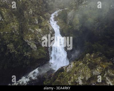 Blick aus der Vogelperspektive auf den majestätischen Wasserfall Fervenza do Toxa, umgeben von üppigem Grün und zerklüfteten Felsen, Silleda, Pontevedra, Spanien. Stockfoto