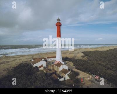 Blick aus der Vogelperspektive auf den malerischen Leuchtturm von La Coubre neben dem Sandstrand und dem ruhigen Meer, La Tremblade, Charente-Maritime, Frankreich. Stockfoto