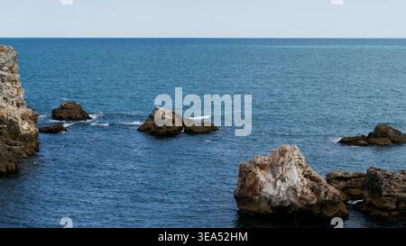 Zerklüftete Küstenklippen und Felsformationen im tiefen Blauen Meer Stockfoto