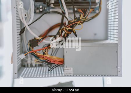 Innenansicht des Computergehäuses mit Netzteil und bunten Kabeln, Nahaufnahme mit Stockfoto