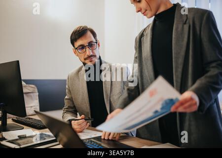 Geschäftsteam diskutiert Projektdokumente in modernen Büros während eines gemeinsamen Meetings Stockfoto