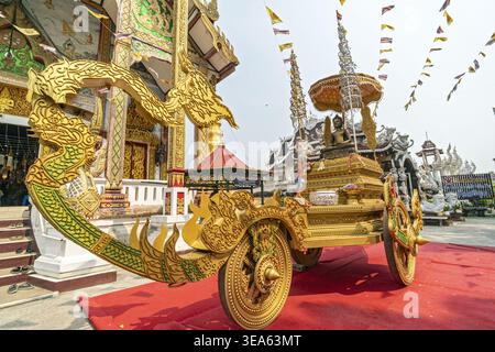 Dok kham Tai, Phayao, Thailand - 20. April 2026: Phra Chao Than Chai, vergoldeter Holzwagen mit Drachenform, der auf rotem Teppich in t Stockfoto