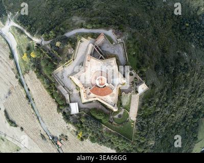 Aus der Vogelperspektive auf das sternförmige Fort Saint-Elme, umgeben von grünen Hügeln und Bäumen in Collioure, Occitanie, Frankreich. Stockfoto