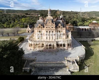 Blick aus der Vogelperspektive auf das prunkvolle Chateau d'Aubiry mit seiner großen Fassade und dem zentralen Turm, umgeben von üppigen grünen Hügeln und Wäldern in Ceret, Occitanie, Fra Stockfoto