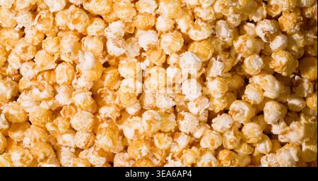 Popcorn gemischt mit Karamell und Butter in einer großen Schüssel für einen Filmabend-Snack Stockfoto