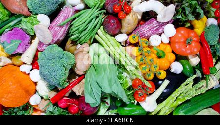 Buntes Gemüse und frische Produkte auf einem Tisch, in dem verschiedene Arten von Speisen in einer lebendigen Präsentation präsentiert werden Stockfoto
