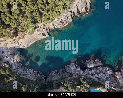 Blick von oben auf die felsige Küste und kristallklares türkisfarbenes Wasser in Cala Aiguafreda, Begur. Stockfoto