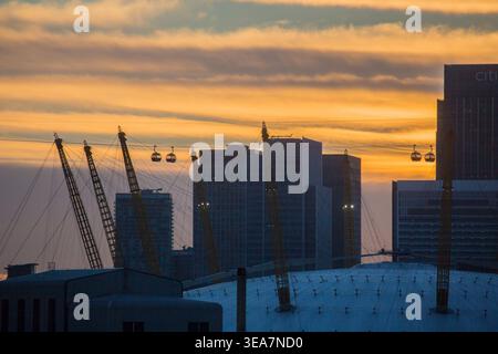 Die London Cable Car, auch bekannt als Dangleway, verbindet die Docklands mit Greenwich; im Hintergrund befinden sich die Hochhäuser von Canary Whar Stockfoto