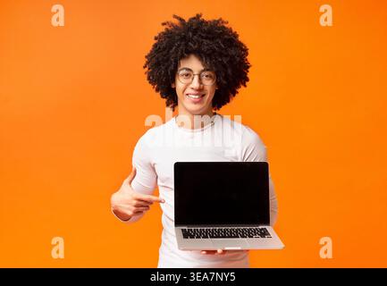 Lächelnd hipster Zeigefinger auf leeren Bildschirm Stockfoto