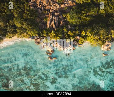 Blick aus der Vogelperspektive auf den Strand von Anse Source d'Argent mit türkisfarbenem Wasser, Granitfelsen und üppigen Palmen, L'Union Estate, Seychellen. Stockfoto