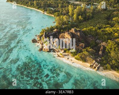 Blick aus der Vogelperspektive auf den Strand von Anse Source d'Argent mit berühmten Granitfelsen, türkisfarbenen Korallenriffen und üppigem tropischem Wald, L'Union Estate, Seychellen. Stockfoto