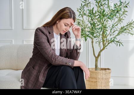 Junge 30er Jahre traurige Frau, die Stress, mentale und körperliche Schmerzen erlebt Stockfoto