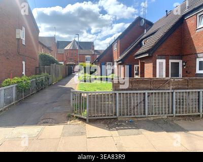 Sonniger Nachmittagsblick auf einen Wohnweg und rote Backsteinhäuser in Northampton Northamptonshire Großbritannien England britischer Lebensstil bewölkter Himmel Geländer Stockfoto