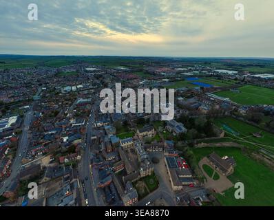 Blick aus der Vogelperspektive auf das historische Stadtzentrum mit Allerheiligen-Kirche, traditioneller Steinarchitektur und umliegenden grünen Feldern unter einem bewölkten Himmel in OA Stockfoto