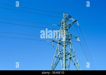 Stahlgitter-Elektrizitätspylon mit mehreren Hochspannungskabeln und Keramikisolatoren Stockfoto