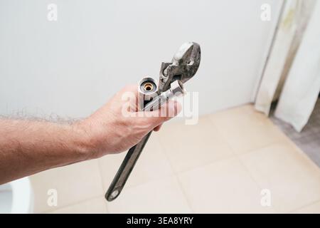 Klempner reparieren eine Toilette, beheben ein Problem mit der Toilette. Klempner bei der Arbeit im Badezimmer, Installationsreparatur, Montage und Installation Konzept Stockfoto