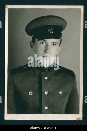 Junger Soldat posiert in Uniform mit einer spitzen Kappe. Authentisches sowjetisches Foto. Stockfoto