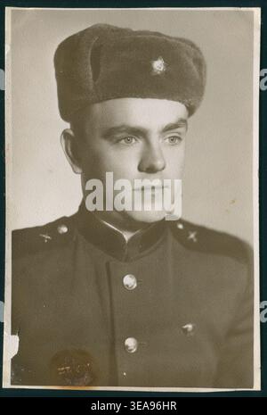 Junge Privatbesetzung in Winterkopfbekleidung mit Komsomol-Abzeichen. Authentisches sowjetisches Foto. Stockfoto