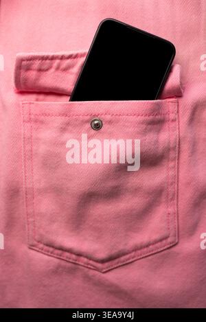Nahaufnahme einer Jeanstasche mit einem pinkfarbenen Aufkleber aus der Tasche Stockfoto