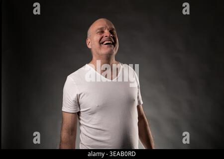 Glatzkopf, der starke Gefühle von Glück und Freude mit einem breiten Lächeln ausdrückt Stockfoto