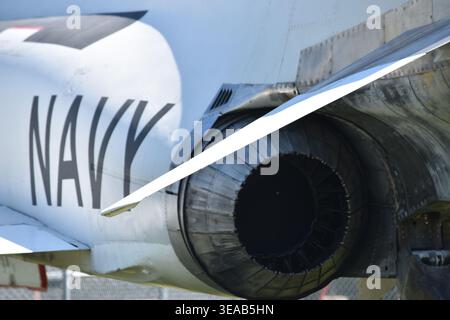 Nahaufnahme eines pensionierten US Navy-Jet-Flugzeugs mit der Auspuffdüse des großen Düsentriebwerks, der Flügelwurzel, dem genieteten Rumpf und dem auffälligen NAVY-Schriftzug. Stockfoto