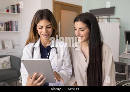 Arzt mit Tablette, die medizinische Scans an die Patientin zeigt Stockfoto