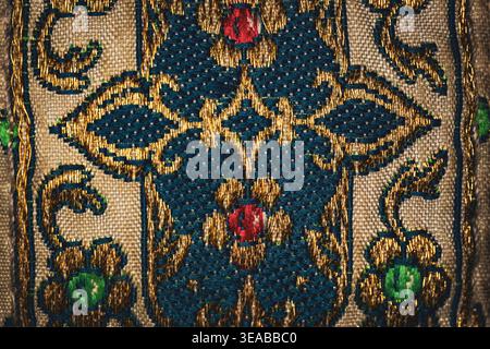 Makronaht aus kunstvoll gewebtem Textil mit Goldfaden und blauem Blumenmuster mit dekorativer Stoffstruktur und komplizierter Stickerei Stockfoto