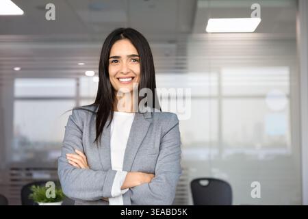 Porträt einer professionellen Geschäftsfrau, die im Büro mit überkreuzten Armen posiert Stockfoto