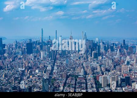 Luftaufnahme des Empire State Building und der Wolkenkratzer von Midtown Manhattan unter einem hellblauen Himmel in New York, New York, USA. Stockfoto