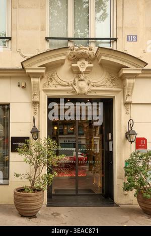 Paris, Frankreich. Oktober 2025. Gebäude in Paris mit einem kunstvollen Eingang, der die Straßenszene widerspiegelt und Gastfreundschaft andeutet Stockfoto