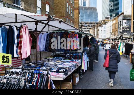Bekleidungsstände mit £5 Hemden und Herrenmode auf dem Petticoat Lane Market in der Middlesex Street in der Nähe von Spitalfields, East London, England, Großbritannien, mit City of Lon Stockfoto
