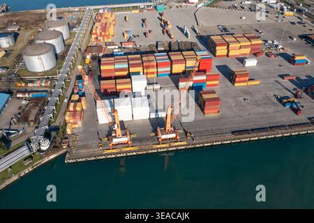 Containerterminal für globale Logistik, Frachtkräne, gestapelte Versandcontainer, Infrastruktur für Frachthäfen, Lieferkette für Importe und Industriehäfen aus der Luft Stockfoto