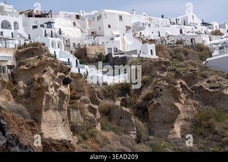Vulkanische Felsformationen und Luxussuiten in Oia - Santorin. Stockfoto