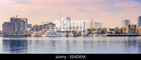 10. Januar 2026, Dubai, VAE: Malerische Uferpromenade am Creek bei Sonnenuntergang mit Yachten, Luxusgebäuden und dem Burj Khalifa, der sich über der pulsierenden Stadt erhebt Stockfoto