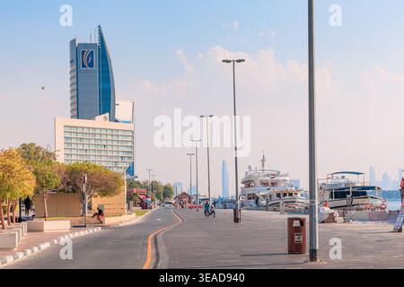 9. Januar 2026, Dubai, VAE: Creek Deira Uferpromenade mit moderner Stadtlandschaft, Straße und angedockten Booten unter einem klaren blauen Tag Stockfoto