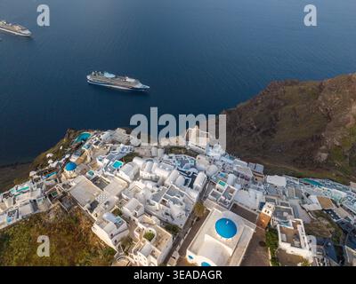Blick aus der Vogelperspektive auf die Blauen Kuppeln von Imerovigli und die Caldera in Santorin, Griechenland. Stockfoto
