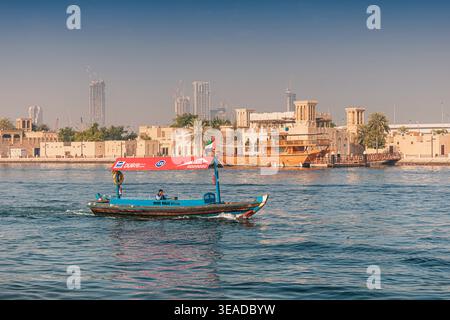 12. Januar 2026, Dubai, VAE: Abra-Boot, das Passagiere über den Creek transportiert und die traditionelle Architektur des historischen Stadtviertels Al Fahidi zeigt Stockfoto