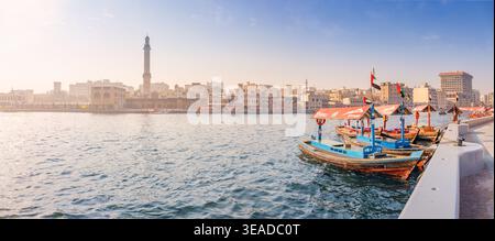 12. Januar 2026, Dubai, Vereinigte Arabische Emirate: Traditionelle Abra-Boote warten auf Passagiere auf Creek, mit der historischen Skyline von Bur Dubai und dem Moscheeminarett im bac Stockfoto